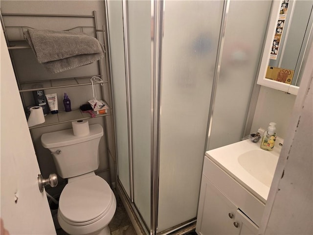 bathroom featuring vanity, toilet, and an enclosed shower