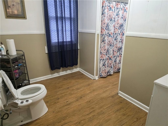 bathroom featuring wood-type flooring and toilet