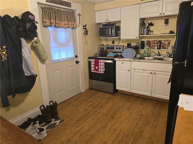 kitchen featuring white cabinetry, stainless steel appliances, sink, and light wood-type flooring