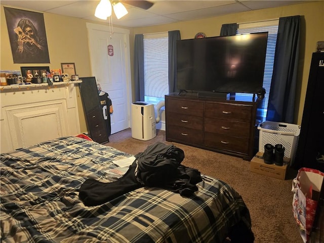 bedroom featuring carpet floors, a drop ceiling, and ceiling fan