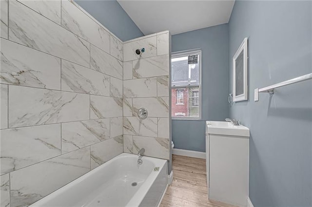 bathroom with tiled shower / bath combo, vanity, plenty of natural light, and wood-type flooring