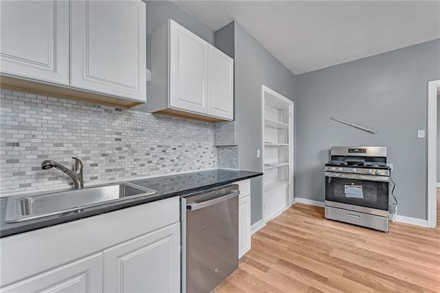 kitchen with sink, light hardwood / wood-style flooring, white cabinetry, backsplash, and stainless steel appliances