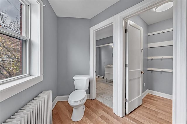 bathroom featuring radiator, hardwood / wood-style flooring, and toilet