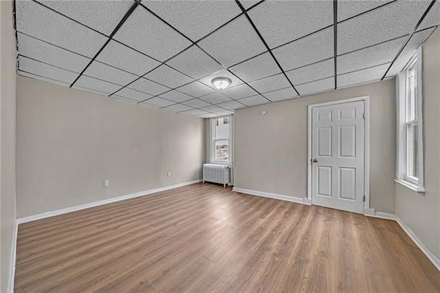 basement featuring radiator heating unit, wood finished floors, and baseboards