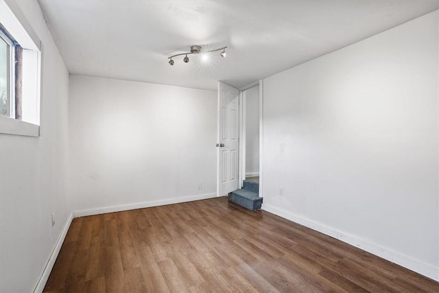 empty room featuring hardwood / wood-style floors and track lighting