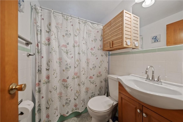 bathroom with tile walls, vanity, toilet, and a shower with shower curtain