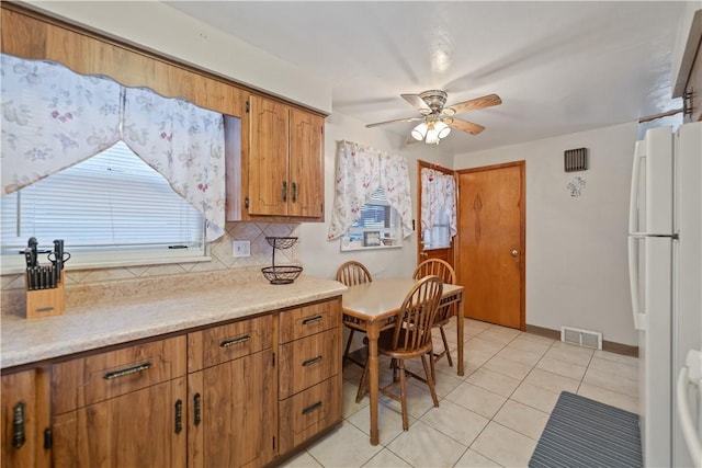 kitchen with tasteful backsplash, white fridge, light tile patterned floors, and ceiling fan