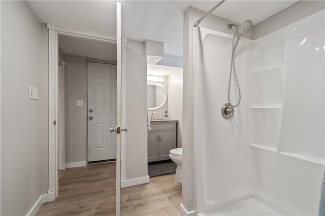 bathroom with wood-type flooring, a shower, vanity, and toilet