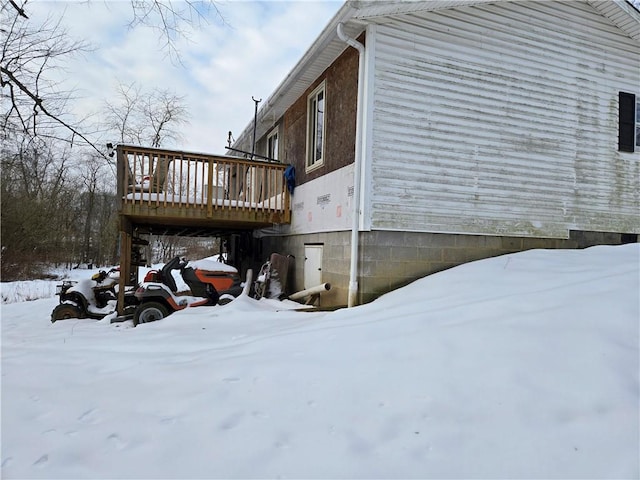 view of snowy exterior featuring a deck