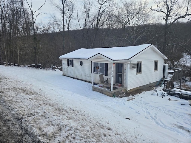 view of front facade featuring a wooded view