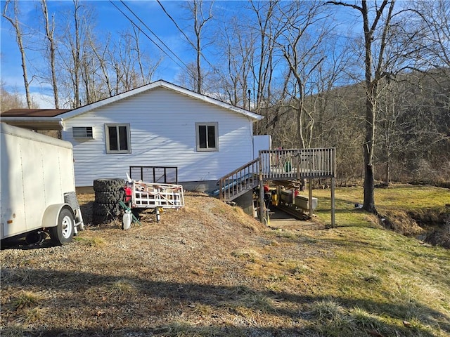 view of property exterior with stairs and a deck