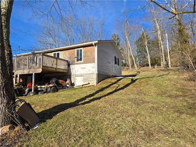 view of side of home featuring a lawn and a wooden deck