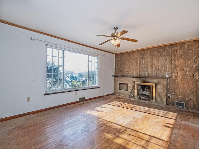 unfurnished living room featuring hardwood / wood-style flooring, ornamental molding, and ceiling fan