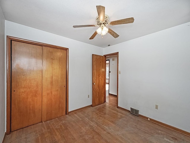 unfurnished bedroom with light hardwood / wood-style floors, a closet, and ceiling fan