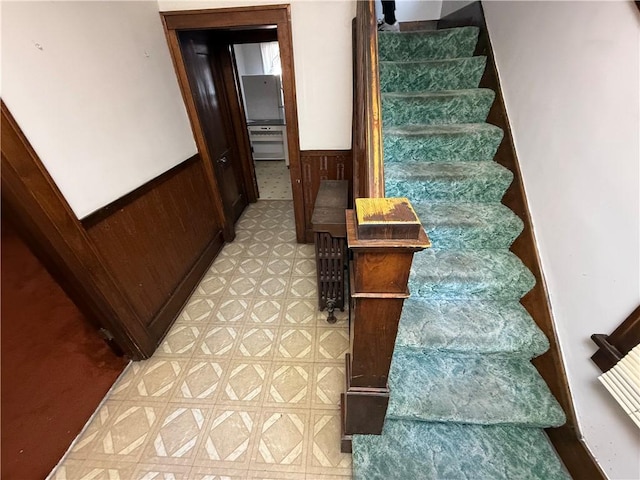 staircase featuring wood walls