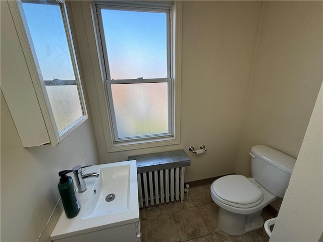 bathroom with radiator heating unit, toilet, and sink