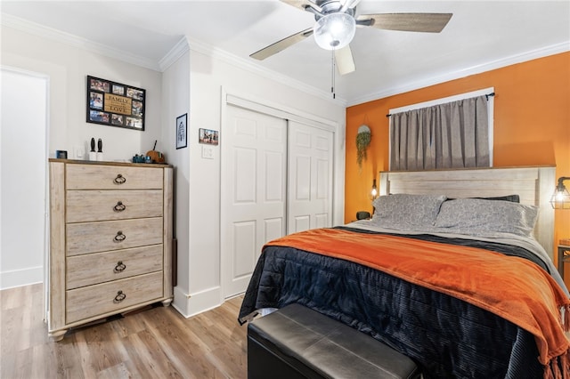 bedroom featuring crown molding, ceiling fan, light hardwood / wood-style floors, and a closet