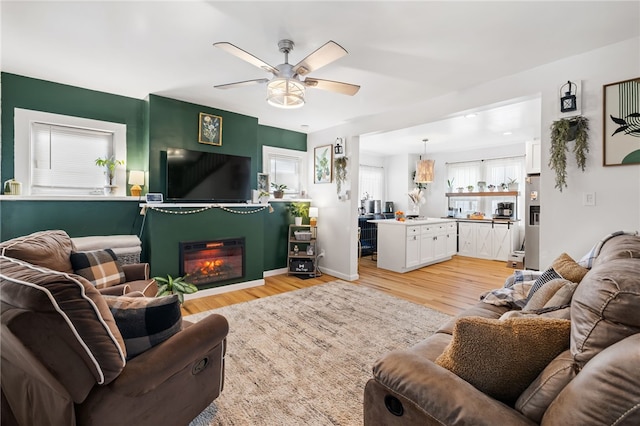 living room with light hardwood / wood-style flooring and ceiling fan