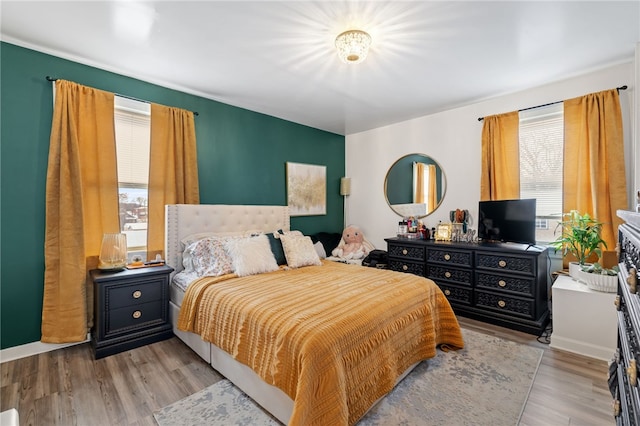 bedroom with multiple windows and light hardwood / wood-style flooring