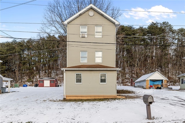 view of snow covered exterior with a storage shed