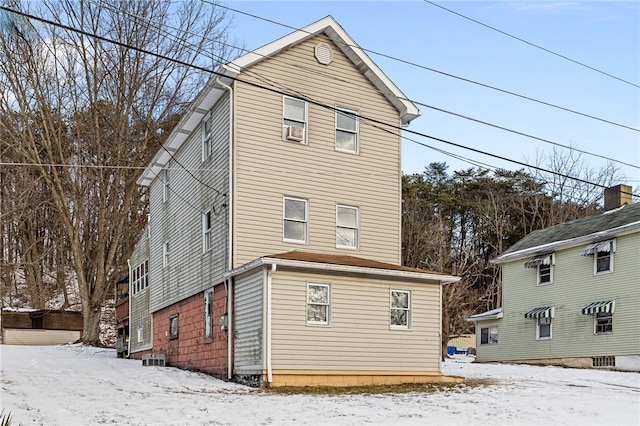 view of snow covered rear of property