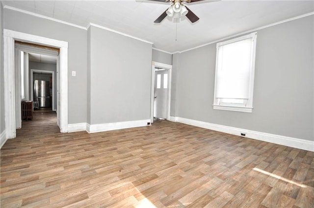 spare room featuring light hardwood / wood-style flooring, ornamental molding, and ceiling fan