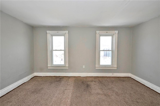 unfurnished room with a wealth of natural light and carpet