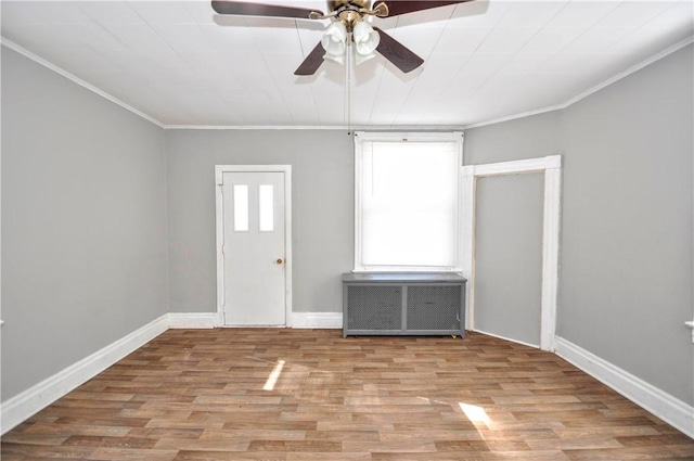 interior space featuring crown molding, ceiling fan, radiator, and light hardwood / wood-style floors