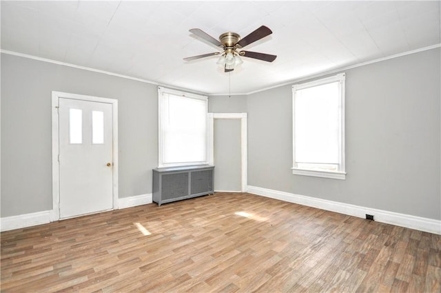 foyer entrance featuring ornamental molding, radiator heating unit, ceiling fan, and light wood-type flooring