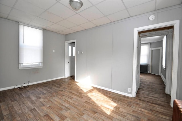 spare room featuring a paneled ceiling, dark hardwood / wood-style flooring, and radiator