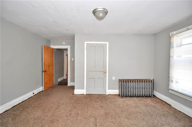 unfurnished bedroom with multiple windows, carpet floors, and radiator