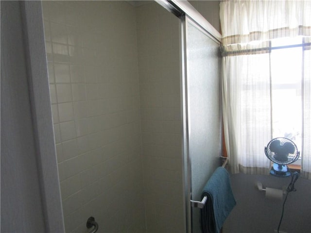 bathroom featuring a shower with door and plenty of natural light