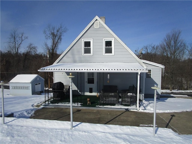 view of front of property with a garage, an outbuilding, and covered porch