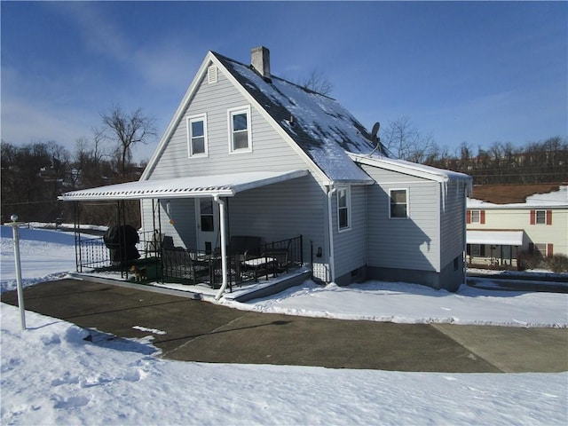 snow covered property with covered porch