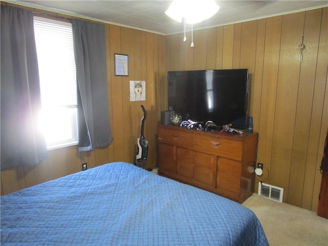 bedroom featuring ornamental molding and wood walls