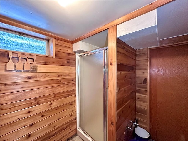 bathroom with an enclosed shower and wood walls