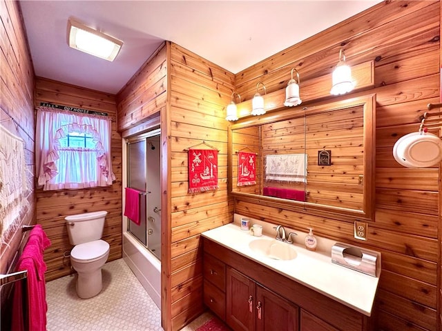 full bathroom with wood walls, enclosed tub / shower combo, vanity, and toilet