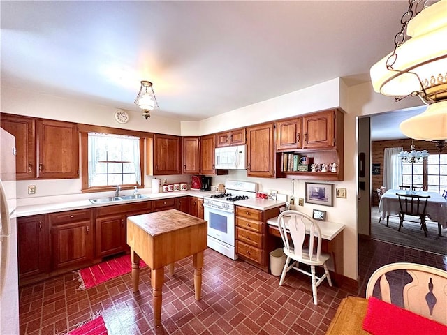 kitchen featuring hanging light fixtures, white appliances, and sink