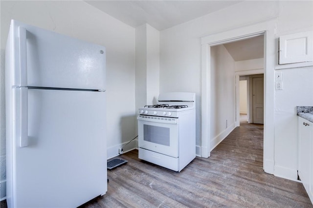 kitchen with white appliances and light hardwood / wood-style flooring