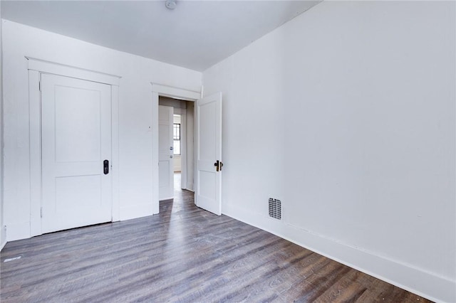 unfurnished bedroom with dark hardwood / wood-style flooring