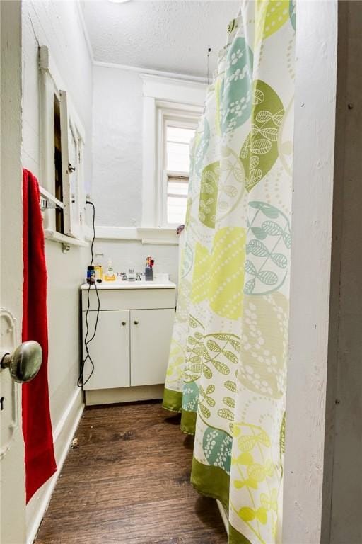 bathroom featuring ornamental molding, sink, hardwood / wood-style floors, and a textured ceiling