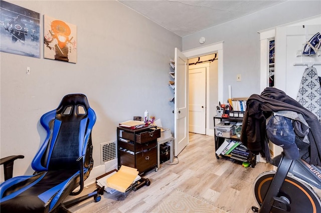 home office with light hardwood / wood-style flooring