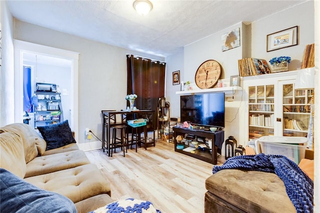 living room featuring light hardwood / wood-style flooring and a textured ceiling