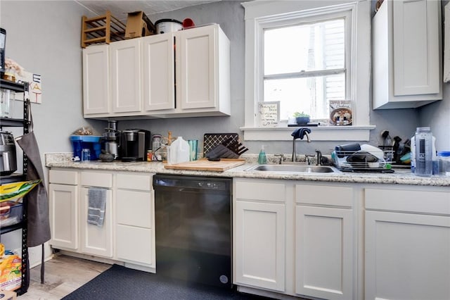 kitchen featuring sink, light hardwood / wood-style flooring, dishwasher, light stone counters, and white cabinets