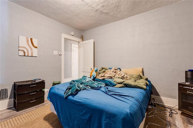 bedroom featuring a textured ceiling and light wood-type flooring