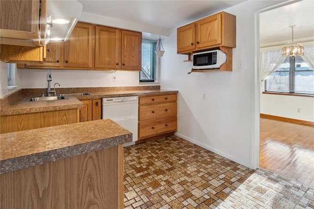 kitchen featuring hanging light fixtures, sink, an inviting chandelier, and white appliances