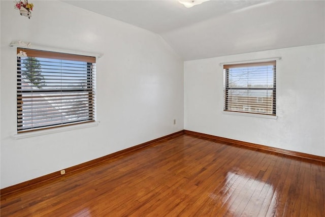 unfurnished room with hardwood / wood-style flooring and vaulted ceiling