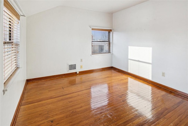 unfurnished room featuring wood-type flooring and vaulted ceiling