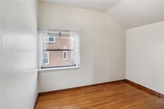 empty room featuring vaulted ceiling and light hardwood / wood-style floors