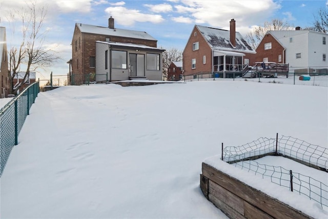 view of snow covered rear of property